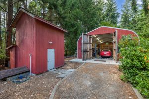 View of pump house with 3000 gallon water storage tank on the left, quonset style shop straight ahead.