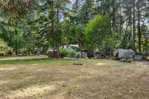 Back field showing wood storage shed, quonset hut (auto shop), and staging area for equipment to be shipped.