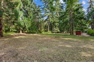 North field to right of driveway entrance, with wood storage shed next to the gravel drive - quonset hut not visible to the right.