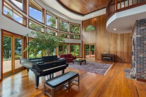 The Great Room has plenty of space for a concert grand piano, furniture, plants, dining and entertaining. The high ceiling creates great acoustics for live music. During nicer weather, the spectacular view of Puget Sound draws people through the multiple sliding doors onto the brick patio for dining, morning coffee, or just relaxing. On the north wall beyond the fireplace are 22' high redwood planks reclaimed from Christian Brothers Winery in California.