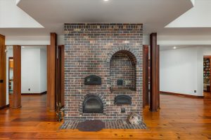 In winter, the masonry brick "Russian Fireplace" may be the center focus when in use. A baking slot above the firebox can cook potatoes, casseroles, even pizza. The cast iron cooktop has a separate smaller firebox, which the owners mostly used during occasional power outages.