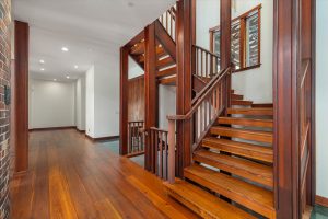 Custom built stairways lead from the main entry hall to the upper and lower levels, located behind the Great Room's Russian Fireplace. Facing the north, this end of the hall leads to the main entry on the right, just past the stairwell, the Master Bedroom on the left, the master closet and laundry room on the right.