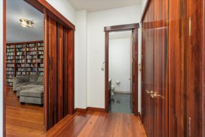 South main floor hall ends at the powder room, with media room to the left and coat closet on the right