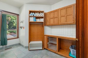 Laundry room with slide-out clothes baskets, folding counter, and overhead shelving