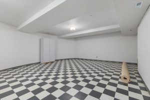 Finished basement from entry door, facing north, toward the area formerly set up with backdrops and studio lights for a photography studio