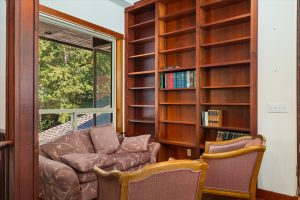 Library shelves and reading nook with east facing windows toward woods
