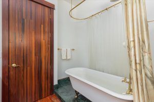 Upper level full bathroom showing entry door and clawfoot tub with shower