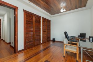 The second upstairs bedroom was (and is) used as another office space, though all but a corner computer desk and foldout table have been removed. Hand made fir closet doors have slats to provide ventilation, and the redwood ceiling and long leaf yellow southern pine floors continue.