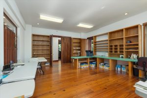 Main executive office on upper level, facing double doors leading to hallway, directly across from the full bathroom