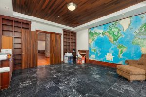 Second story executive office with world map, facing double entry doors to the hallway